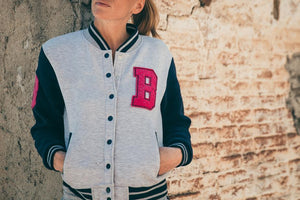 woman wearing light gray cotton varsity jacket